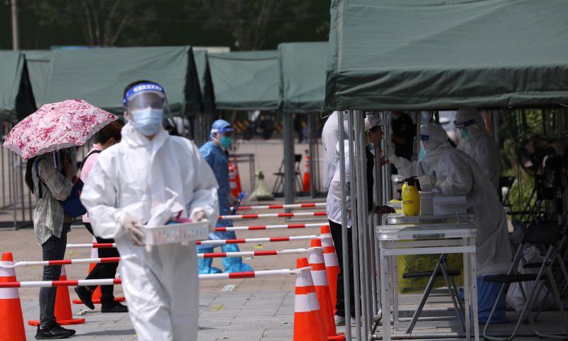 A medical worker collects a swab from a person at a nucleic acid testing site at a park, following new cases of Covid-19 in Beijing, China. &mdash; Reuters/File