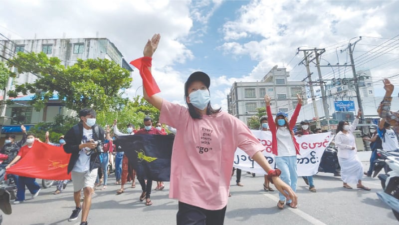 MANDALAY: An anti-coup protester shows the three-finger salute during a march on the anniversary of the 1988 uprising on Sunday.&mdash;Reuters