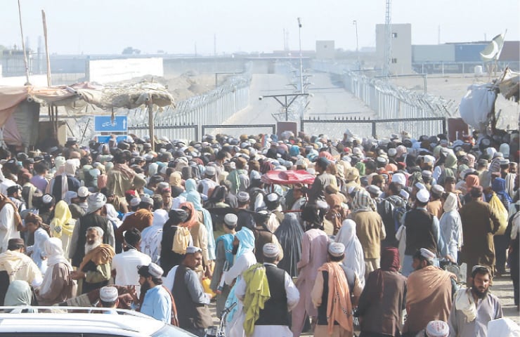 CHAMAN: Stranded people gather on Wednesday to seek information from security forces about opening of the border crossing between Pakistan and Afghanistan, which was closed by authorities a few days ago. Normally, thousands of Afghans and Pakistanis cross the border daily and a steady stream of trucks passes through, taking goods to landlocked Afghanistan from Karachi.—AP