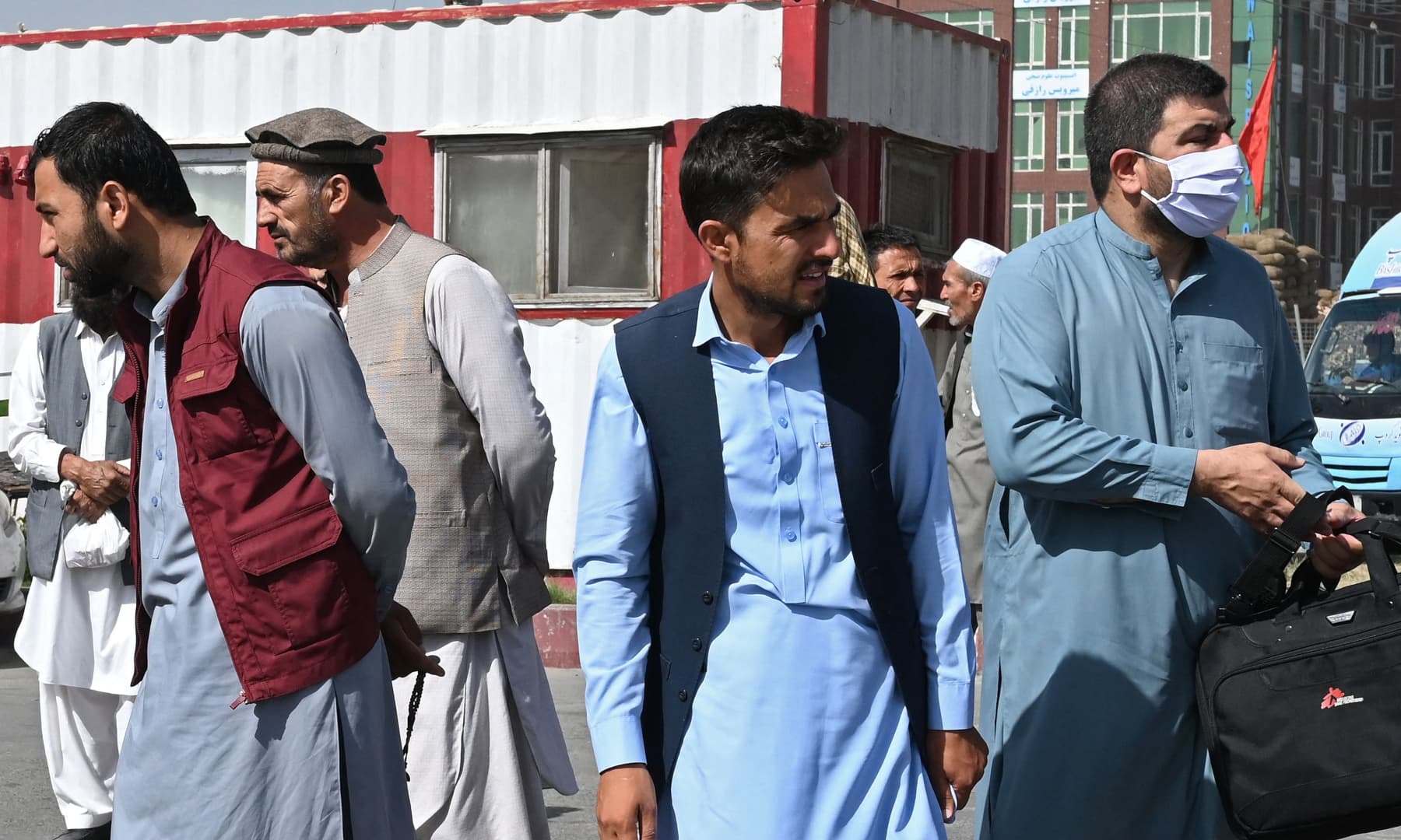 Afghan people stand along the roadside as they wait for a taxi in Kabul, Afghanistan on Aug 15, 2021. — AFP