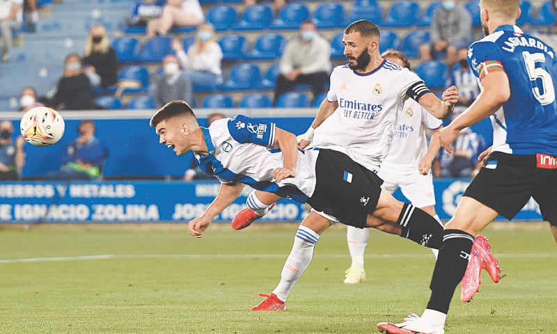 VITORIA: Real Madrid&rsquo;s Karim Benzema (C) vies for the ball with Alaves&rsquo; Pere Pons during their La Liga match at the Mendizorroza Stadium.&mdash;AFP