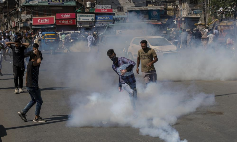 A Kashmiri Shia mourner kicks an exploded tear gas canister during a procession in central Srinagar area of Indian occupied Kashmir on Tuesday. — AP