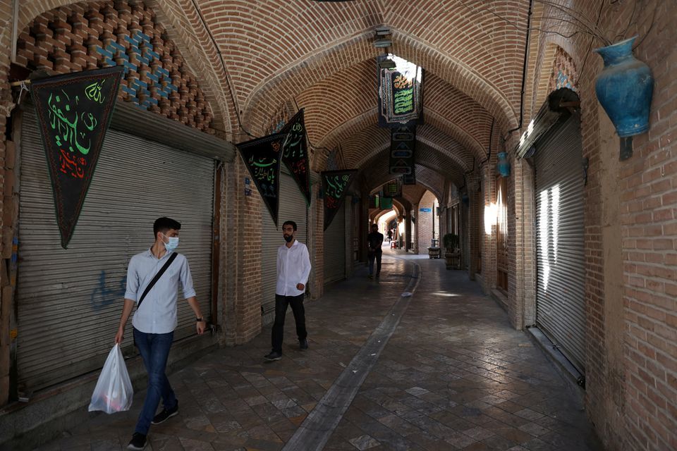 People walk past closed shops in the Tehran Bazaar after the tightening of coronavirus restrictions, in Tehran, Iran on August 16. —Reuters