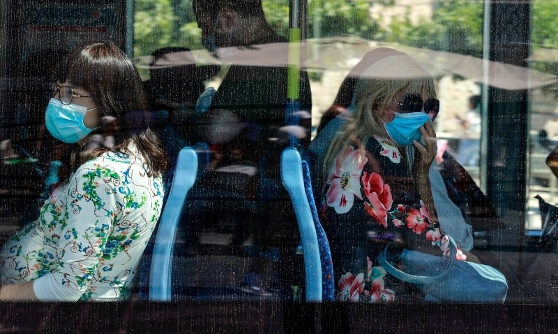 Israelis wear face masks inside a bus after authorities tightened restrictions to curb a surge in infections in central Jerusalem on August 19. — AFP