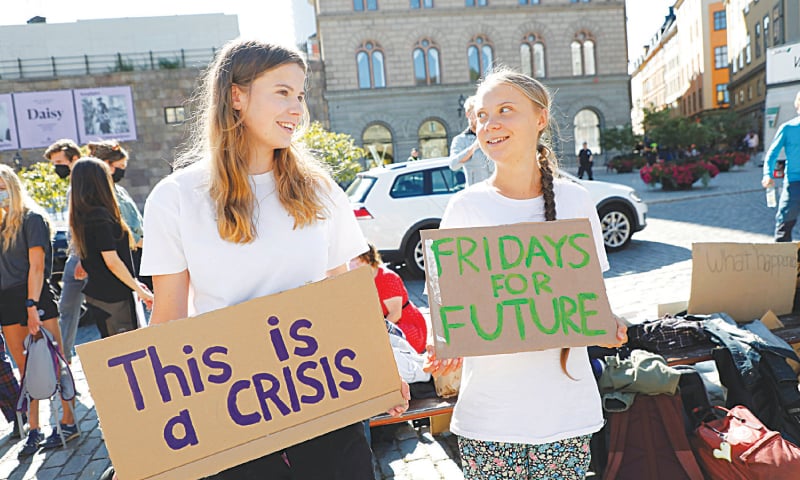 STOCKHOLM: Swedish climate activist Greta Thunberg and her German associate Luisa Neubauer hold placards during a protest outside Sweden&rsquo;s parliament as part of Fridays for Future demonstrations.&mdash;Reuters