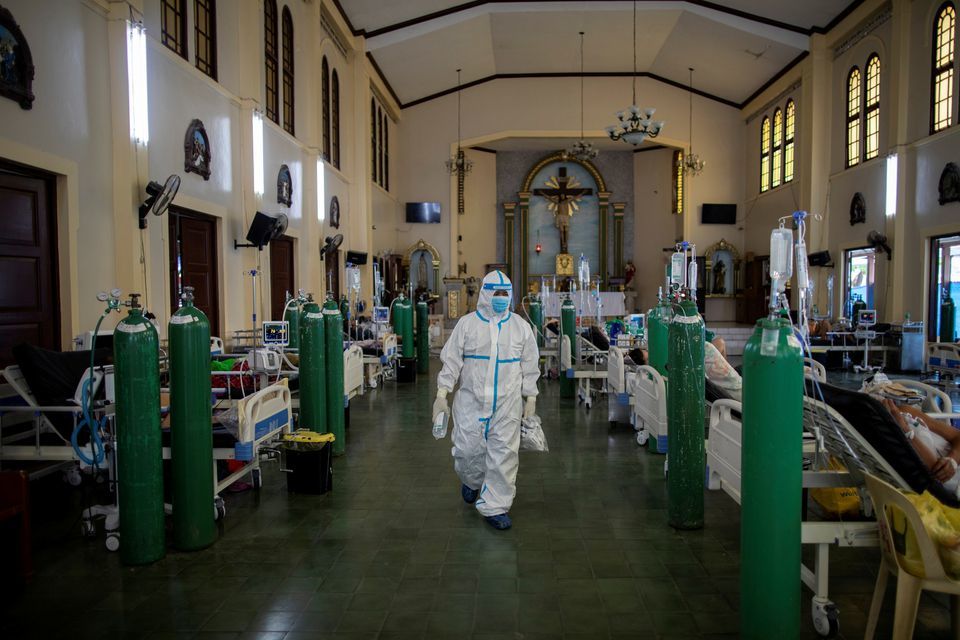 A health worker walks around to check on coronavirus patients admitted in the chapel of Quezon City General Hospital in Quezon City, Metro Manila, Philippines on August 20. — Reuters