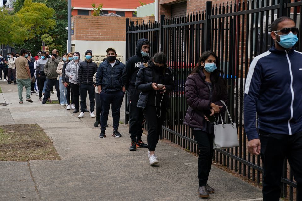 People wait in line outside a coronavirus vaccination clinic in the Bankstown suburb during a lockdown to curb an outbreak of cases in Sydney, Australia on August 25. — Reuters