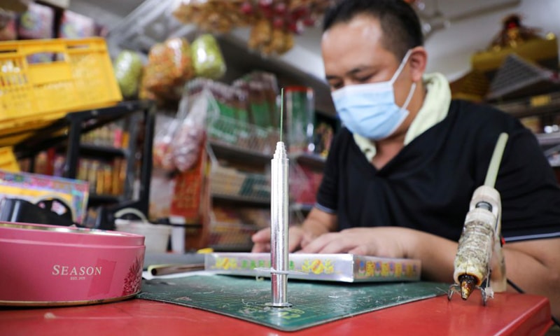 Prayer paraphernalia shop owner Raymond Shieh makes handmade paper vaccines at his shop in Johor Bahru, Malaysia. &mdash; Reuters
