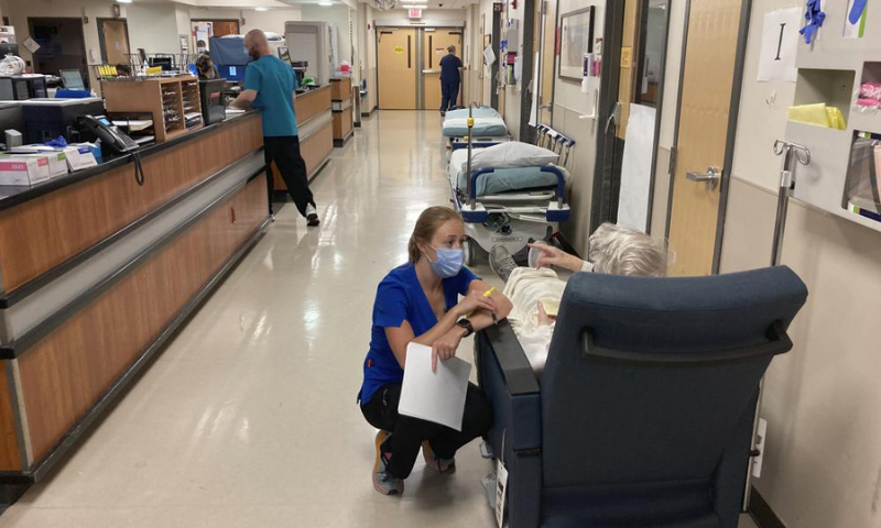 In this Aug 20 file photo, a nurse talks to a patient in the emergency room at Salem Hospital in Salem, Oregon, with gurneys lining the hallway behind them, ready to take patients if needed. — AP