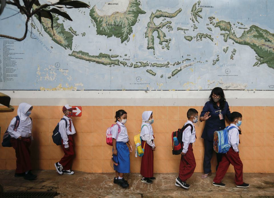 Elementary school students wearing face masks stand in line after a class as schools reopen on a trial basis in Jakarta, Indonesia on August 30. &mdash; Reuters