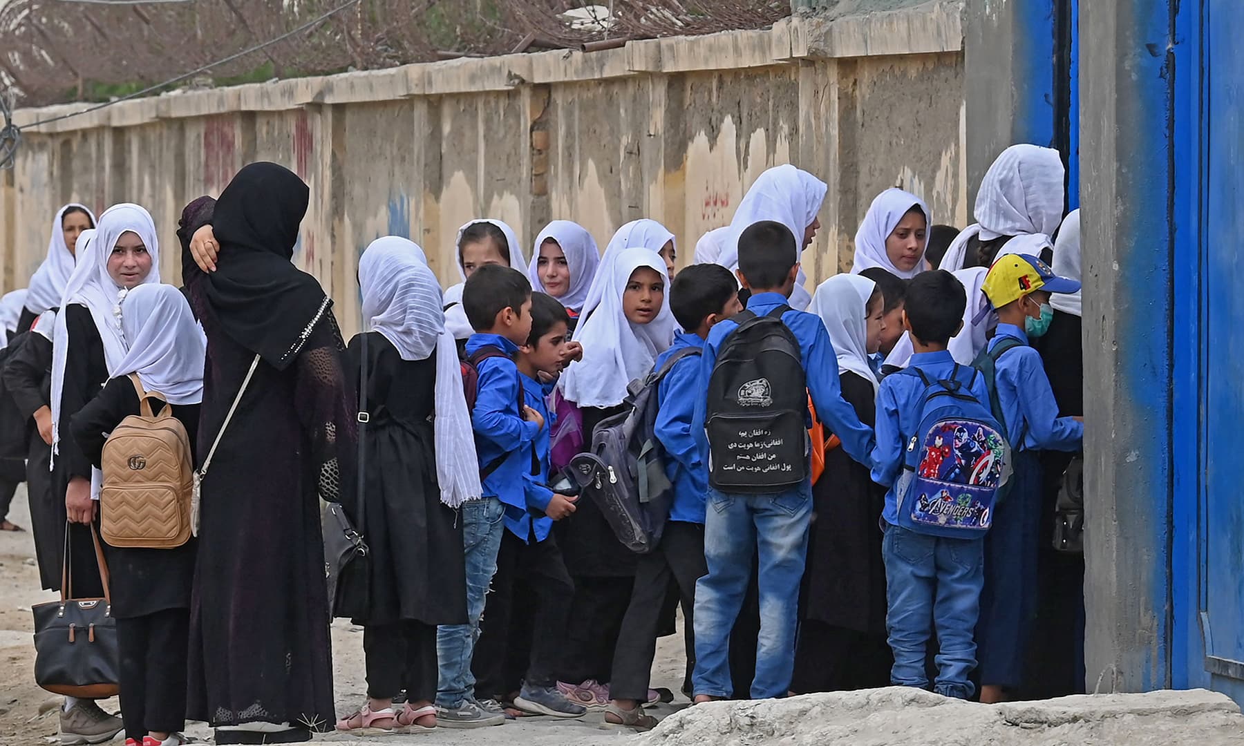 Students arrive to attend their morning classes at a government middle school in Kabul on August 30. — AFP