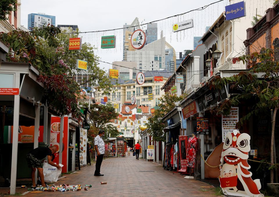 A man recycles aluminium drink cans in the largely empty Chinatown tourist district, Singapore on August 30. — Reuters