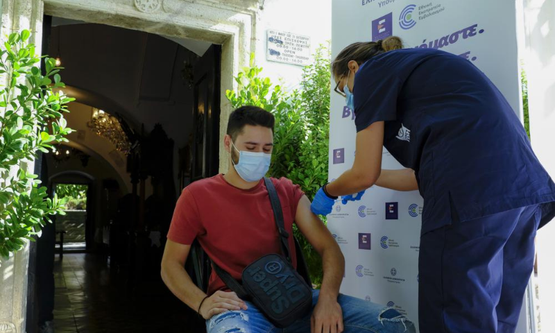 A young man receives a dose of the Johnson and Johnson Covid-19 vaccine outside the church of the Virgin Mary, during a vaccination drive in the town of Archanes, on the island of Crete, Greece, on Monday. — AP