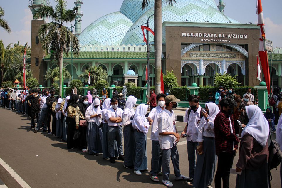 Students wearing protective masks stand in line to receive a vaccine dose against the coronavirus during a mass vaccination programme for students at the Tangerang City Government Centre on the outskirts of Jakarta, Indonesia on September 2. &mdash; Reuters