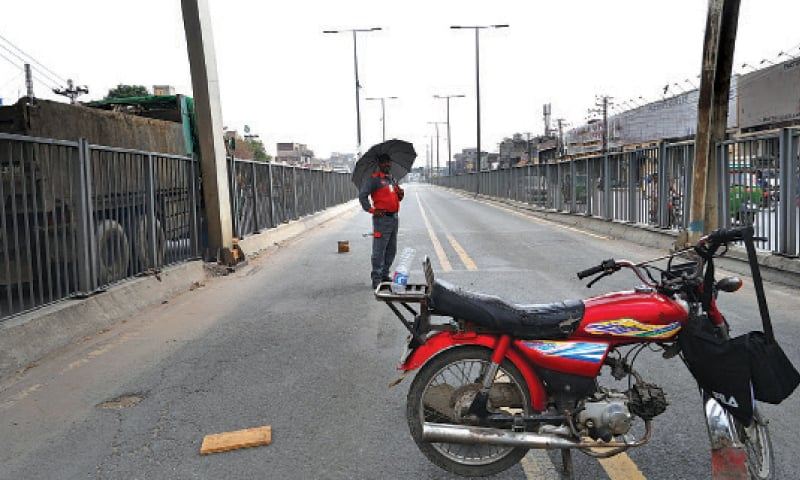 A Metro bus employee stands near the Timber Market to stop movement of private vehicles on the track. — White Star A Metro bus employee stands near the Timber Market to stop movement of private vehicles on the track. — White Star
