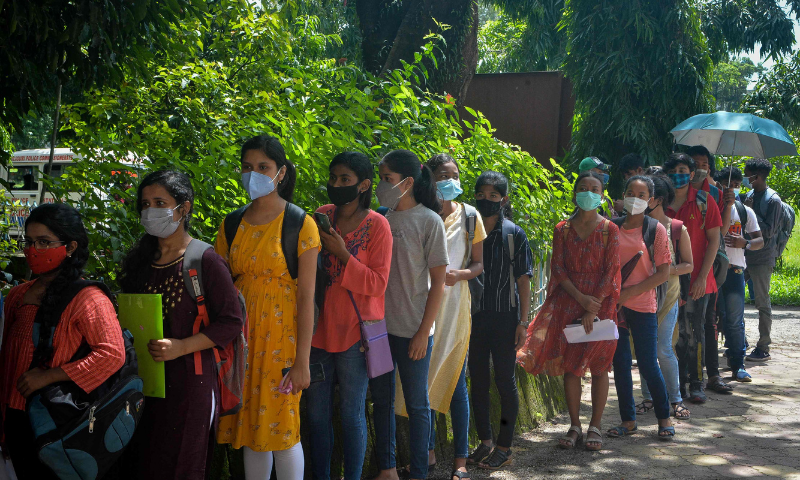 Students queue up to get themselves inoculated with the jab of Covishield vaccine at a vaccination camp in Siliguri, India on Wednesday. — AFP