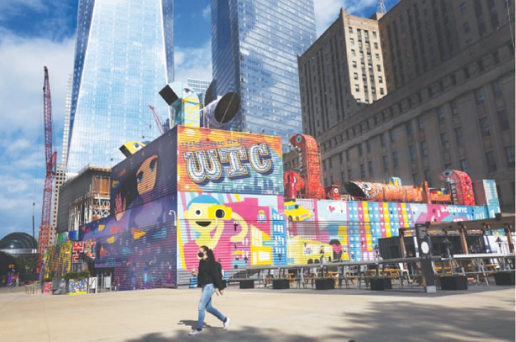 A woman walks by colourful murals that surround the foundation for Two World Trade Center.—AP