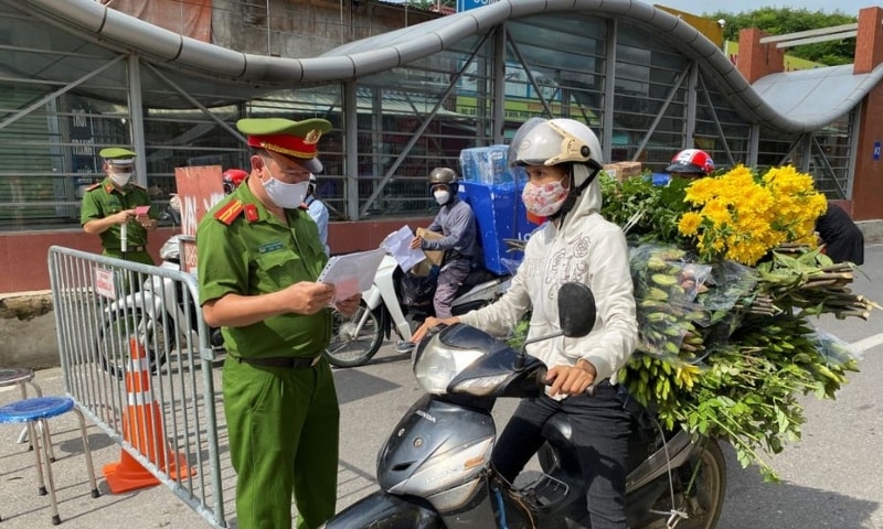 Vietnam police officers inspect authorised travel documents of commuters at a check point during the first day of the extended lockdown in Hanoi, Vietnam, September 6. — Reuters