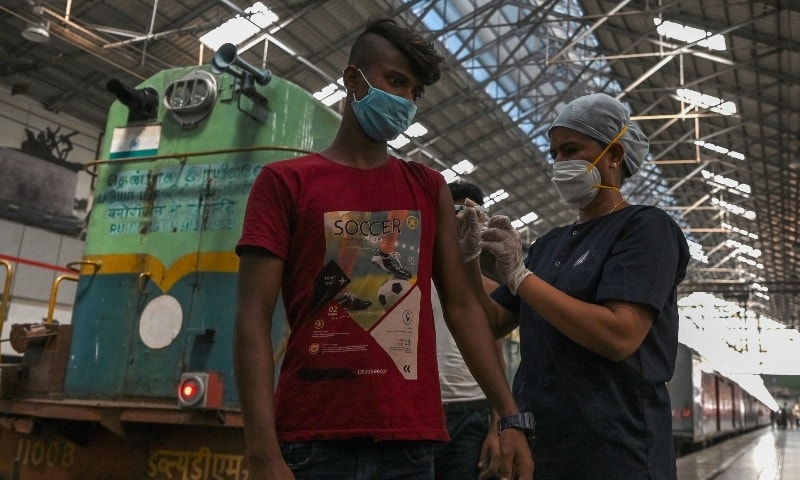 A health worker inoculates a passenger with a dose of the Covishield vaccine at a vaccination camp set up inside a railway station in Chennai on September 19. &mdash; AFP
