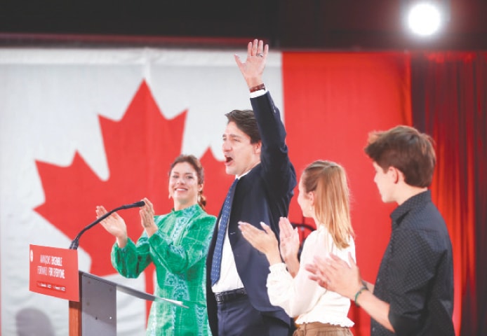 Canadian Prime Minister Justin Trudeau, accompanied by his wife Sophie Gregoire and their children, waves to supporters during an election night party in Montreal on Tuesday.&mdash;Reuters