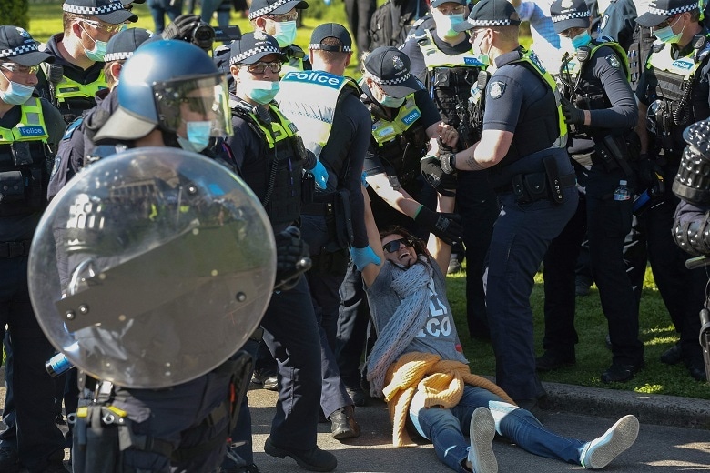 Police detain a woman as construction workers and demonstrators on the steps of the Shrine of Remembrance protest against Covid-19 regulations in Melbourne on Wednesday. &mdash; AFP