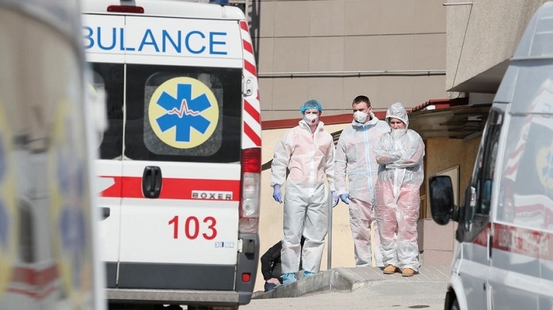 Medical personnel stand next to ambulances with Covid-19 patients as they wait in the queue at a hospital for people infected with coronavirus disease in Kyiv, Ukraine on March 30, 2021. &mdash; Reuters/File