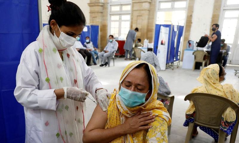 In this file photo, a woman receives a dose of Covid-19 vaccine at a vaccination centre in Karachi. — Reuters/File