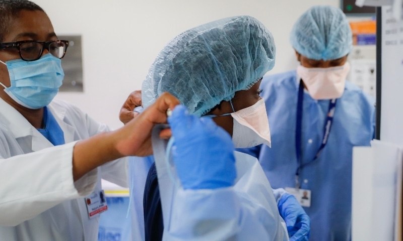 In this file photo, medical personnel adjust their personal protective equipment while working in the emergency department at NYC Health + Hospitals Metropolitan in New York.— AP