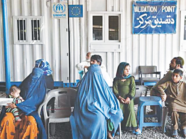 A file photo shows Afghan refugees waiting to get registered at a UNHCR centre in Peshawar | AFP