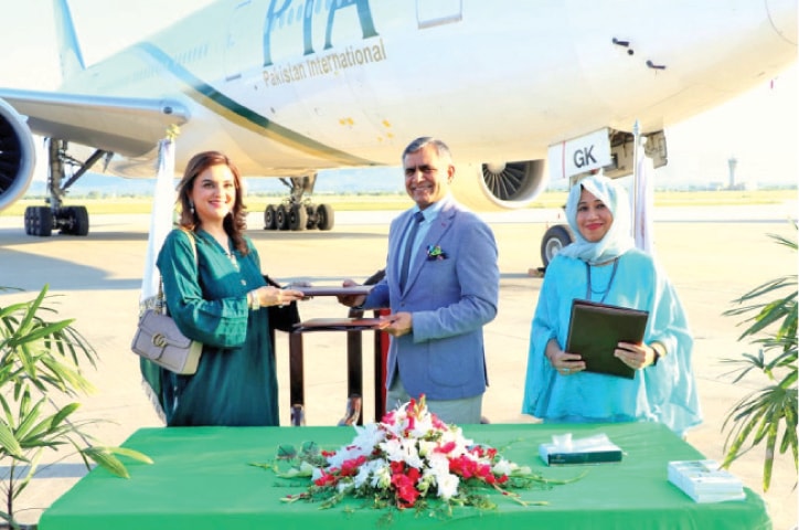 PIA Chief Executive Officer Air Marshal Arshad Malik and Federal Ombudsperson for Protection Against Harassment Kashmala Tariq exchange documents at the MoU signing ceremony.