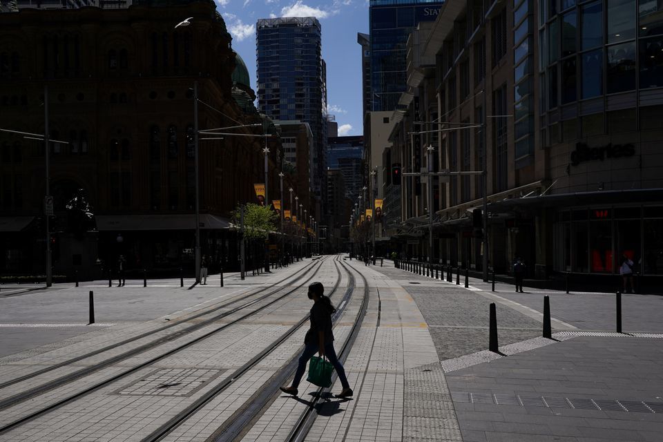 A pedestrian wearing a protective face mask crosses tram lines in the city centre during a lockdown in Sydney, Australia, September 24. — Reuters