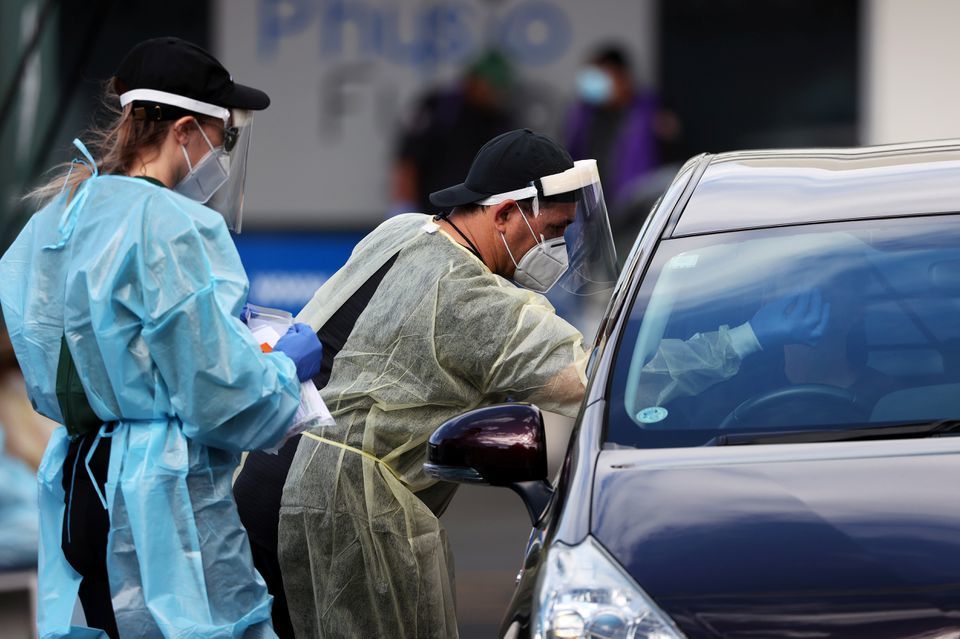 A medical worker administers a Covid-19 test at a testing clinic during a lockdown to curb the spread of a coronavirus outbreak in Auckland, New Zealand, August 26. &mdash; Reuters