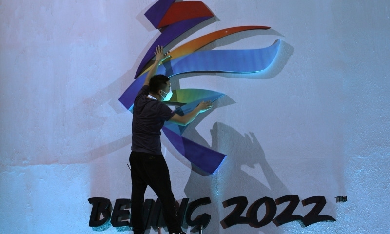 A man adjusts an emblem of the Beijing 2022 Winter Olympic Games before a ceremony unveiling the slogan on September 17. — Reuters