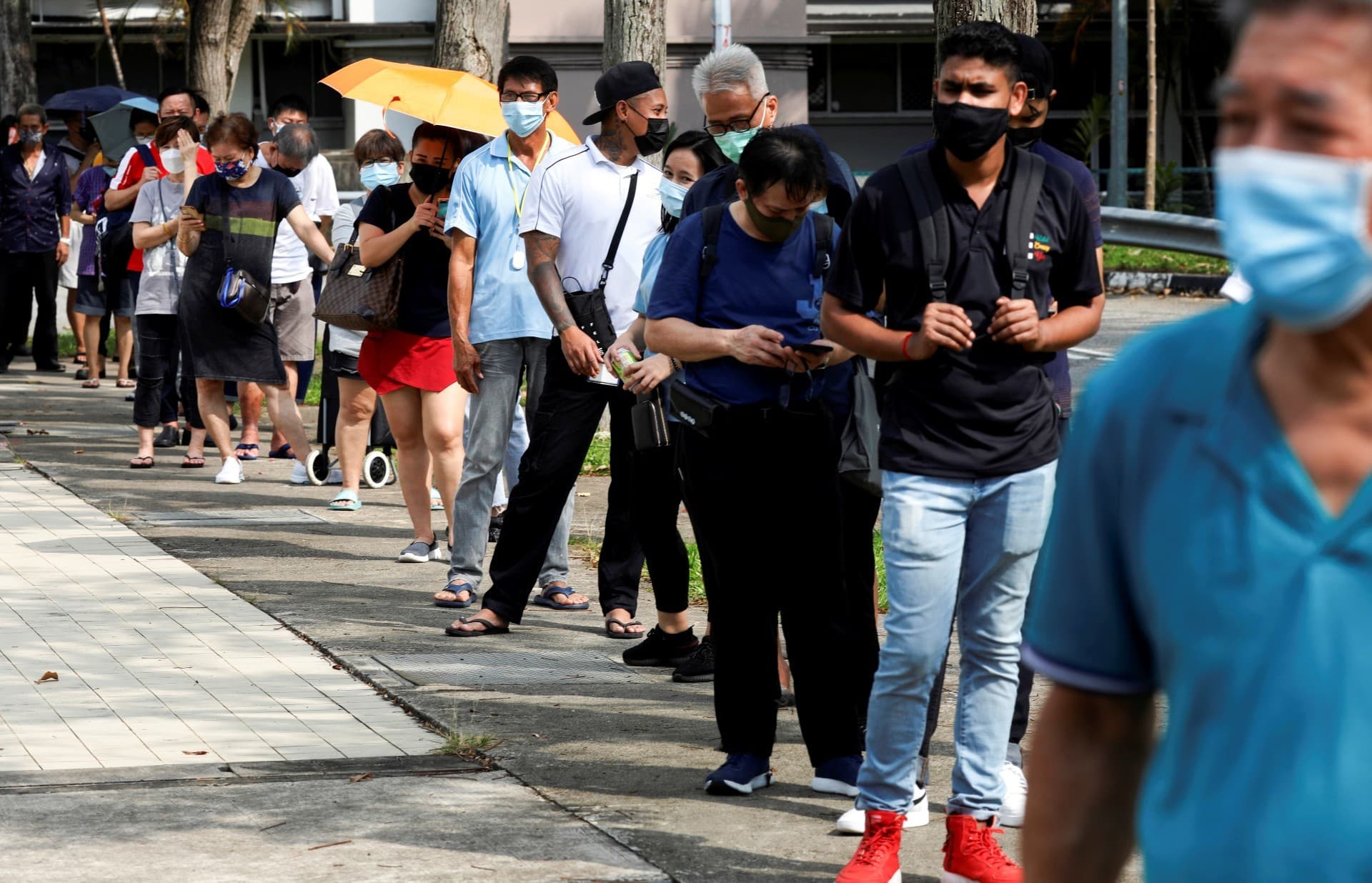 People queue up outside a quick test centre to take antigen rapid tests in Singapore on September 21. &mdash; Reuters