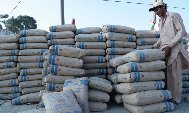 This file photo shows a worker piling cement bags. — AFP/File