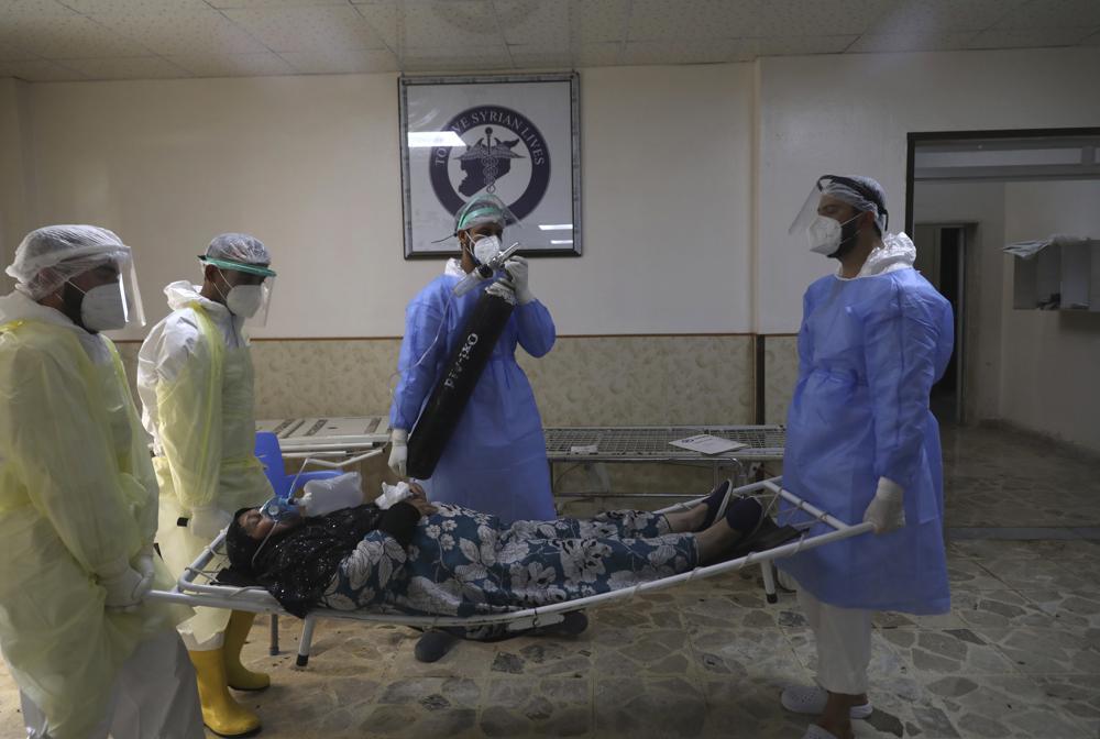 Medical workers carry a patient infected with the coronavirus on a stretcher at the Syrian American Medical Society Hospital, in the city of Idlib, northwest Syria, Sept 20. &mdash; AP