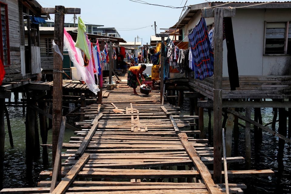 A woman washes clothes on a wooden path between stilt houses at Hanuabada Village, located in Port Moresby Harbour, Papua New Guinea on November 19, 2018. — Reuters