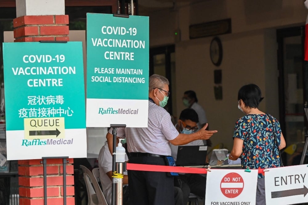 People enter a coronavirus vaccination centre set up at a community centre in Singapore on October 7. — AFP