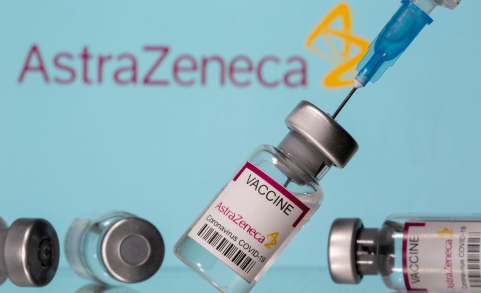 Vials labelled "Astra Zeneca Covid-19 Coronavirus Vaccine" and a syringe are seen in front of a displayed AstraZeneca logo. — Reuters/ File