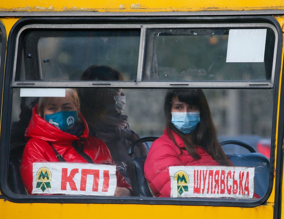 People wear protective face masks sit in a bus amid the ongoing coronavirus outbreak in central Kyiv, Ukraine, September 29. &mdash; Reuters