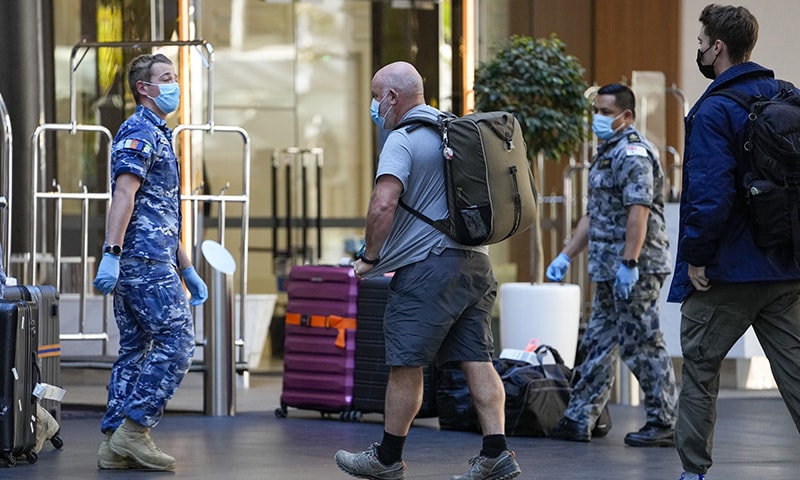 International travelers are met by Australian military personnel as they arrive at a quarantine hotel in Sydney, Australia. &mdash; AP/File