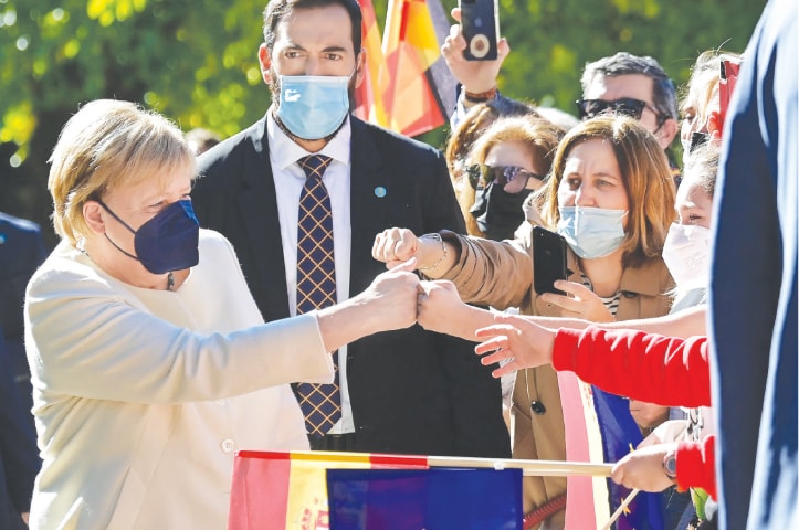 CUACOS DE YUSTE (Spain): German Chancellor Angela Merkel greets Spaniards as she arrives for the Carlos V European Award ceremony at the Royal Monastery of Yuste on Thursday.—AFP