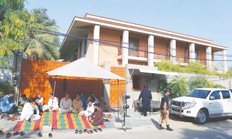 FELLOW tribesmen encamp themselves outside the DHA residence of Agha Siraj Durrani on Thursday to resist any attempt to arrest him by a NAB team, not seen in the picture but present in the vehicles parked in front of the main gate.—PPI