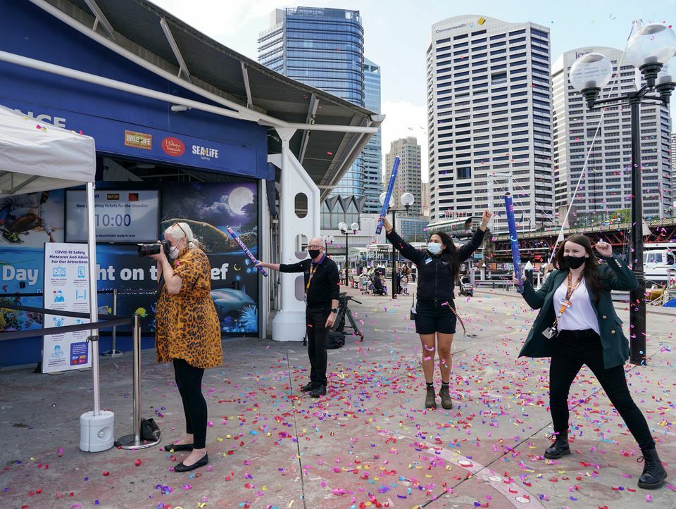 Staff members cheer after shooting confetti in the air to celebrate the re-opening of SEA LIFE Sydney Aquarium to visitors, following an extended closure due to a coronavirus lockdown, in Sydney, Australia, October 14. — Reuters