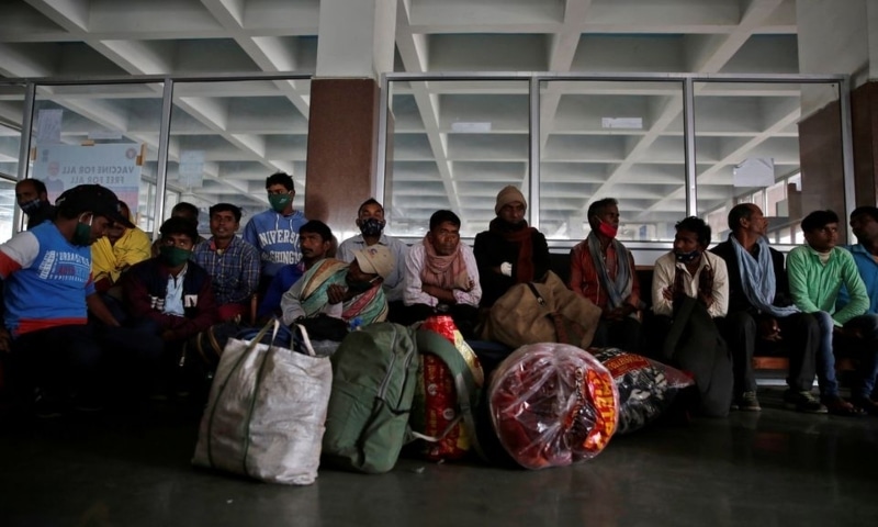 Indian migrant workers wait with their belongings inside a railway station to board trains to their home states following attacks on migrant labourers in occupied Kashmir, on the outskirts of Srinagar, October 18. — Reuters