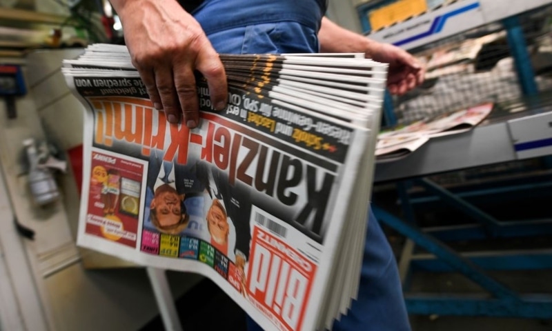 A worker carries printed editions of Bild newspaper that show candidates for chancellor Olaf Scholz, of Social Democratic Party, and Armin Laschet, of Christian Democratic Union, after the first exit polls for the general elections in Berlin, Germany, September 26. — Reuters/File