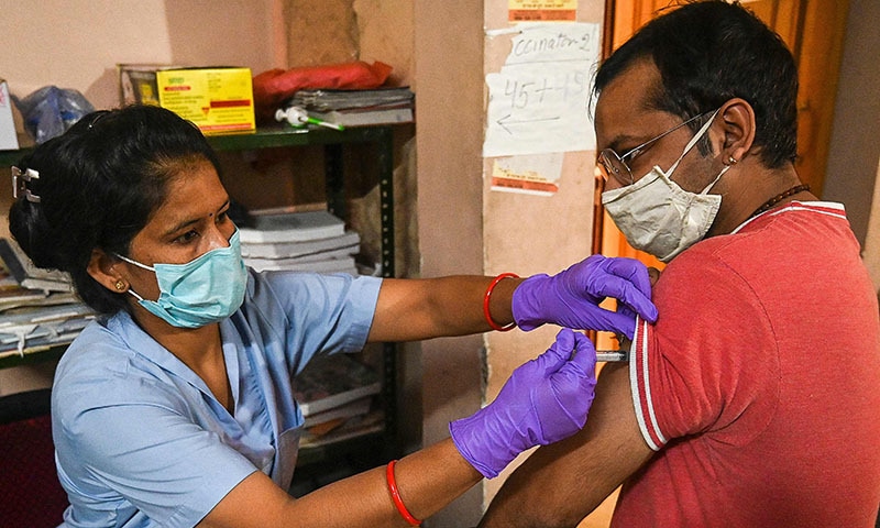 A health worker inoculates a man with a dose of the Covishield vaccine against the coronavirus inside a vaccination centre in Ghaziabad on Wednesday. — AFP