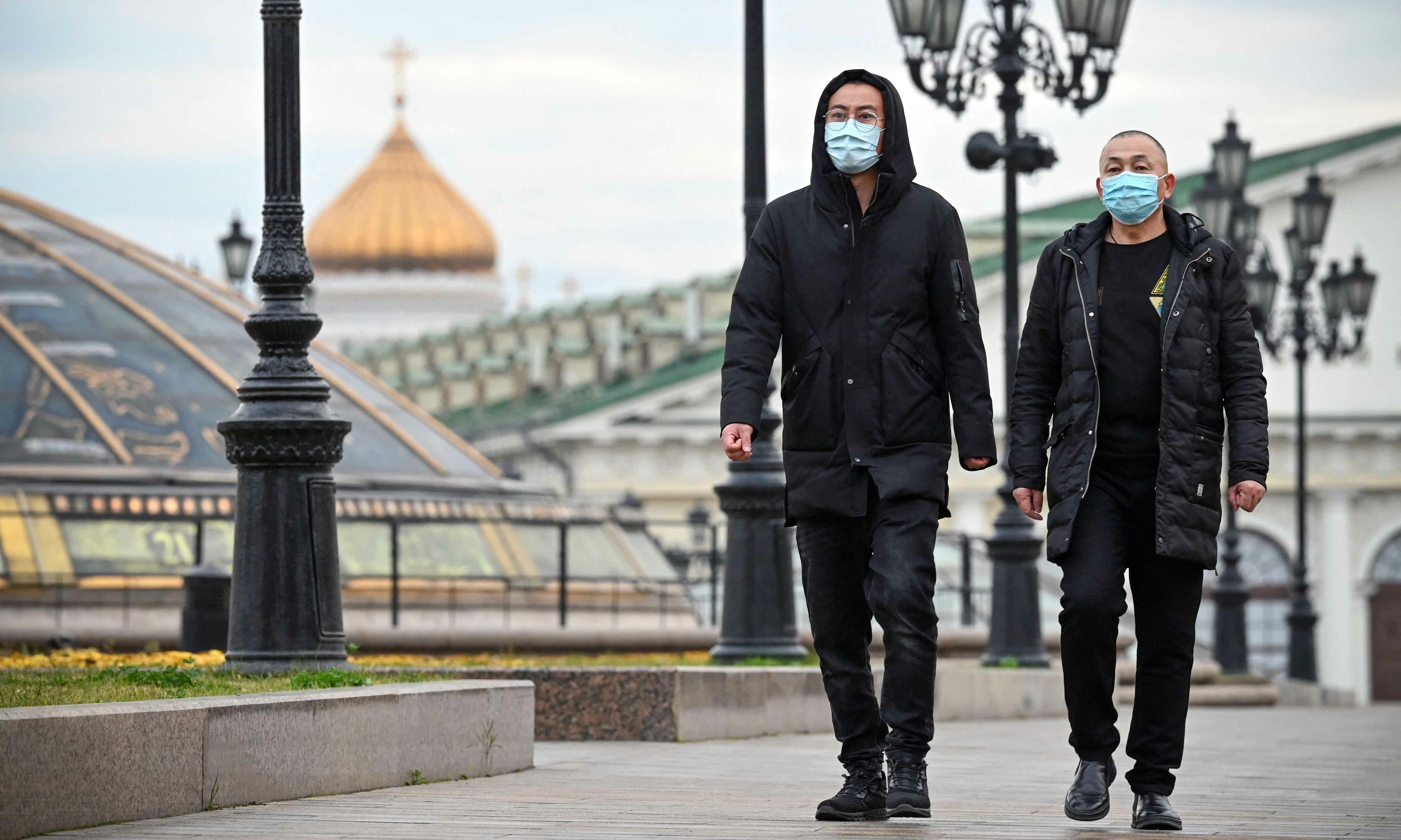 Pedestrians wearing face masks walk in central Moscow on October 22 amid the crisis linked with the Covid-19 pandemic. &mdash; AFP