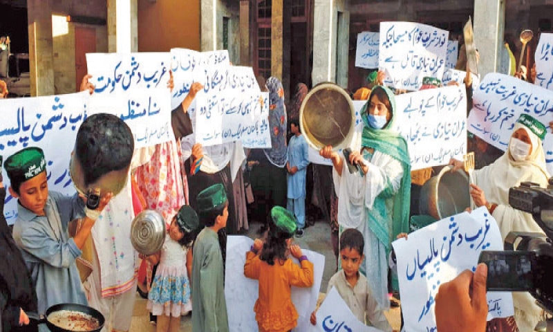 Women and children display placards and kitchenware during a protest staged by the PML-N Women Wing in Sangota, Swat. — Dawn