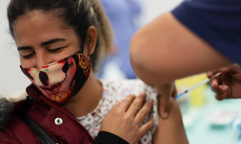A woman receives a dose of Pfizer/BioNTech coronavirus vaccine during a vaccination campaign inside the University of Santiago, Chile on June 30. &mdash; Reuters